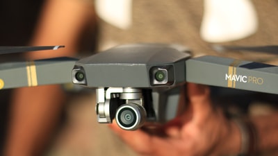 手持灰色DJI Mavic Pro无人机的人